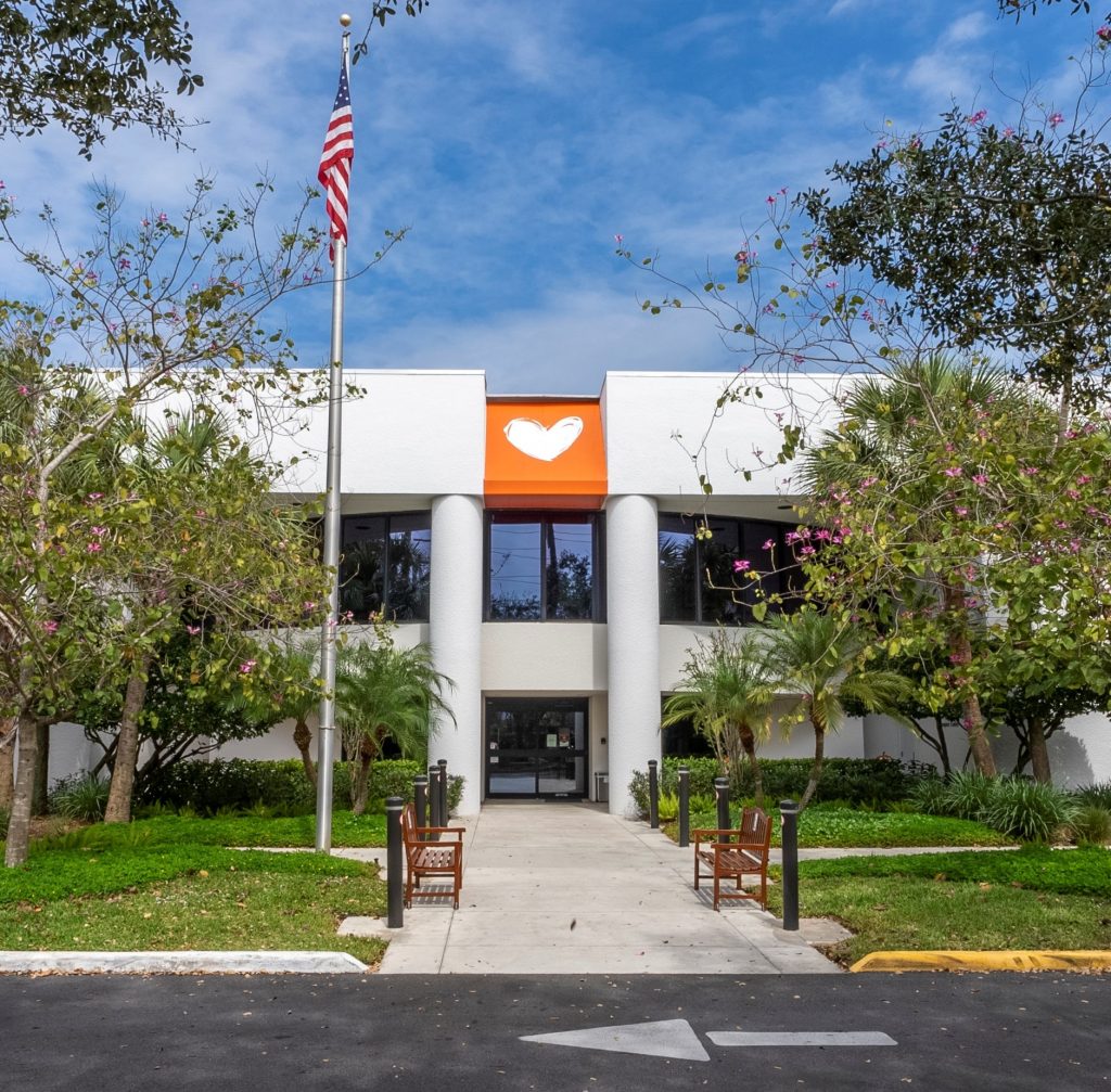 The entrance to the Charles W. Gerstenberg Hospice Center, a two-storey white building with an orange heart sign above the doors