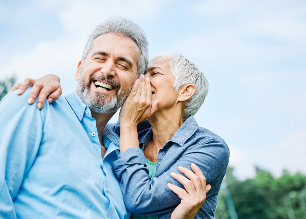 An older couple laughing together outdoors