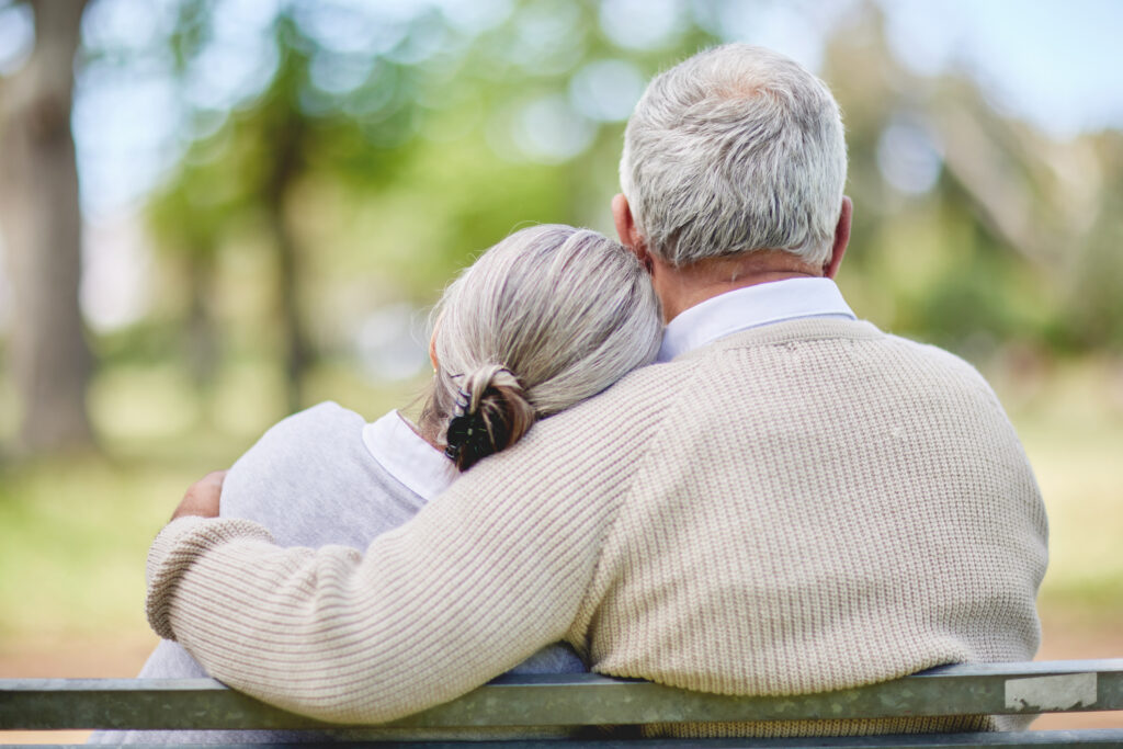 A couple sitting together on a park bench