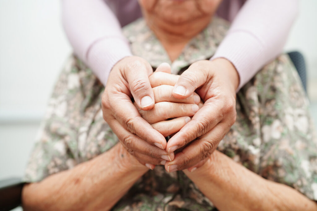 A caregiver holding a patient's hands